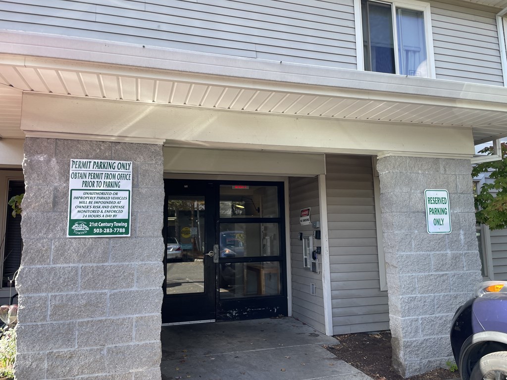 A sign on a pillar outside a building states that the parking is for permit holders only.