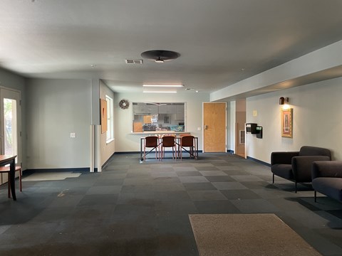 A grey hallway with a table and chairs in the middle.