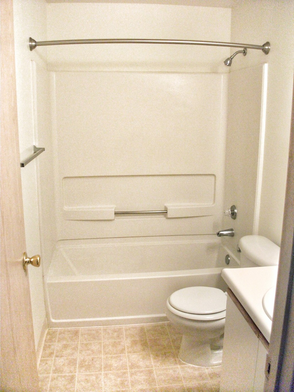 a white bathroom with a toilet and a bath tub