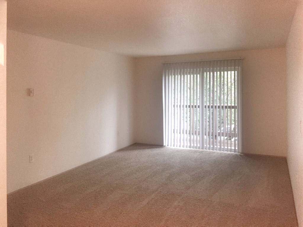 an empty living room with a sliding glass door