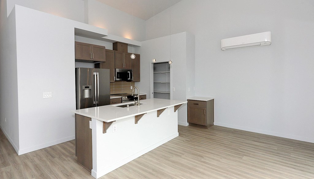 an empty kitchen with a counter top and a refrigerator