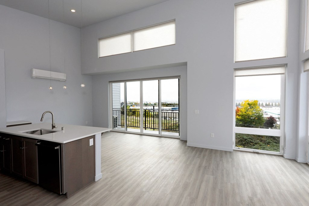 an open kitchen and living room with a view of a balcony