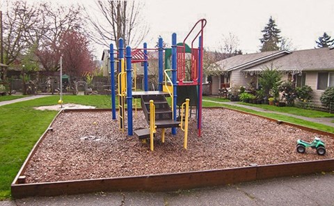 A playground with a red, yellow and blue slide.
