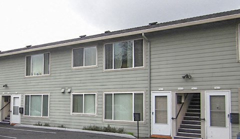 A grey building with white doors and windows.