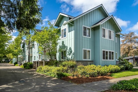 A blue house with a green lawn in front.