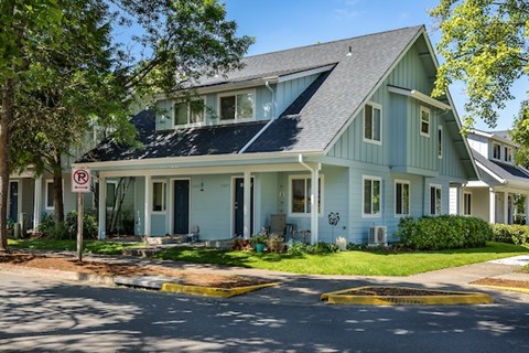 A house with a blue door and a no parking sign in front.