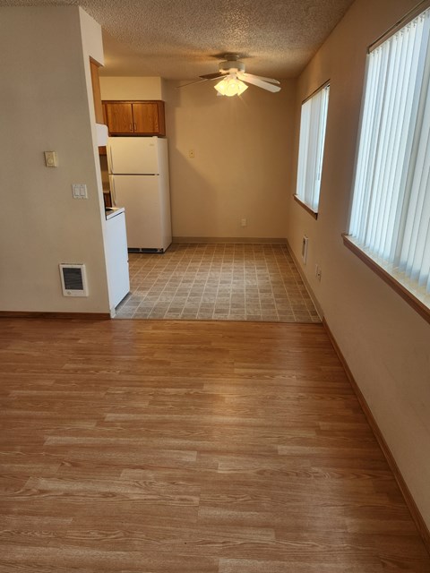 A kitchen with a refrigerator and a ceiling fan.