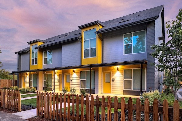 a blue and yellow house with a wooden fence