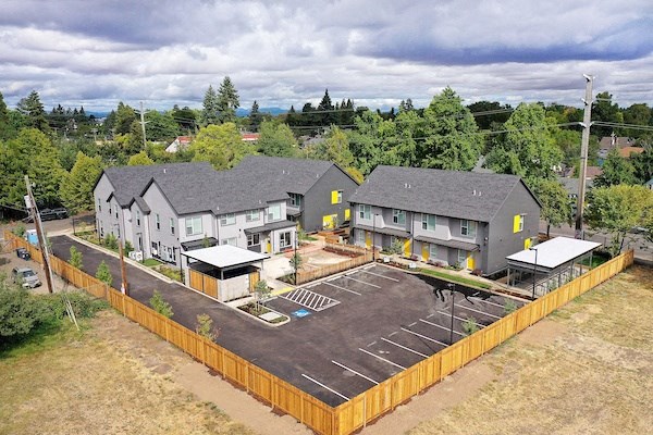 an aerial view of three houses and a parking lot