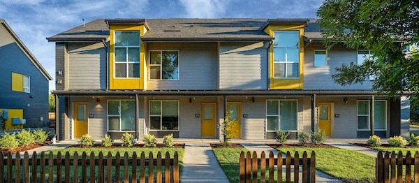 a yellow and with a yard and a fence