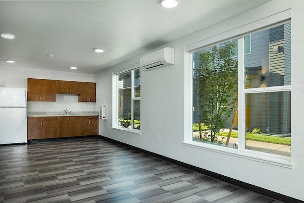 a kitchen with a large window and a wooden floor