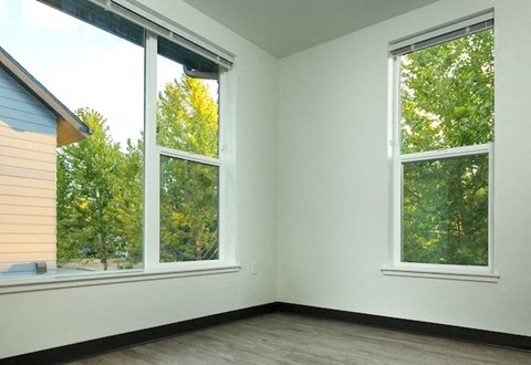 a room with three large windows and a wood floor