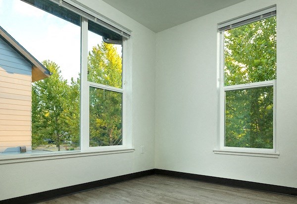 a room with three large windows and a wood floor