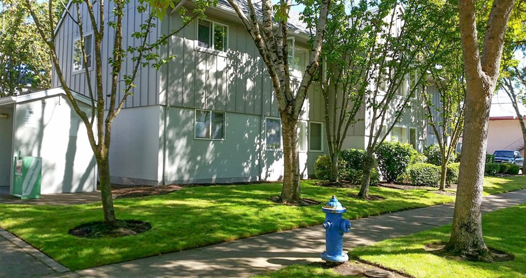 a blue fire hydrant on a sidewalk in front of a building