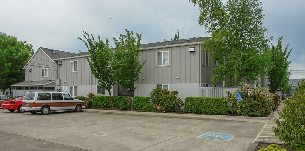 an apartment building with a van parked in a parking lot