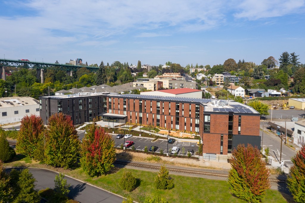 an aerial view of a large brick building with a city in the background