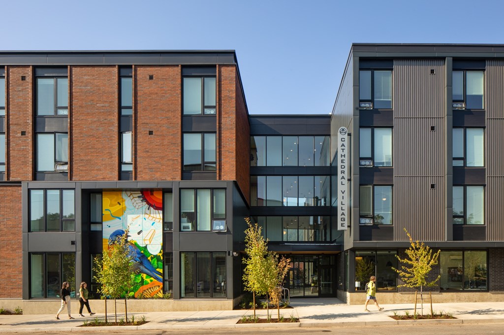 people walking in front of a building with a mural on it