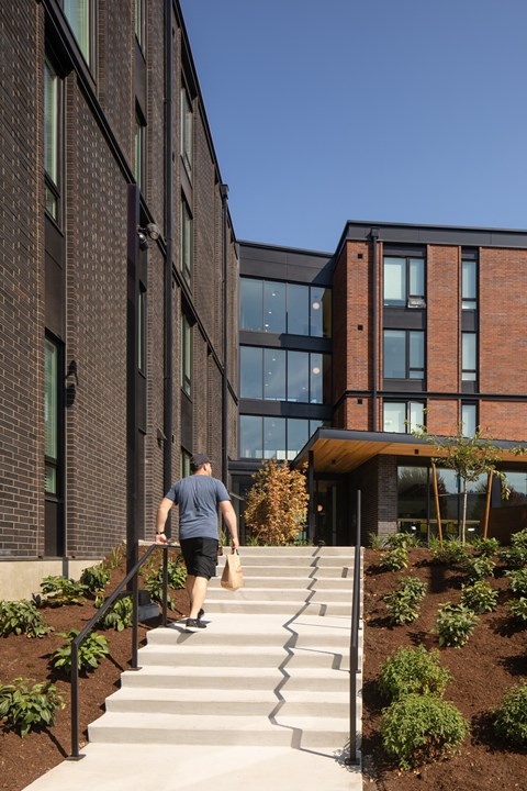 a man walking up a set of stairs in front of a building