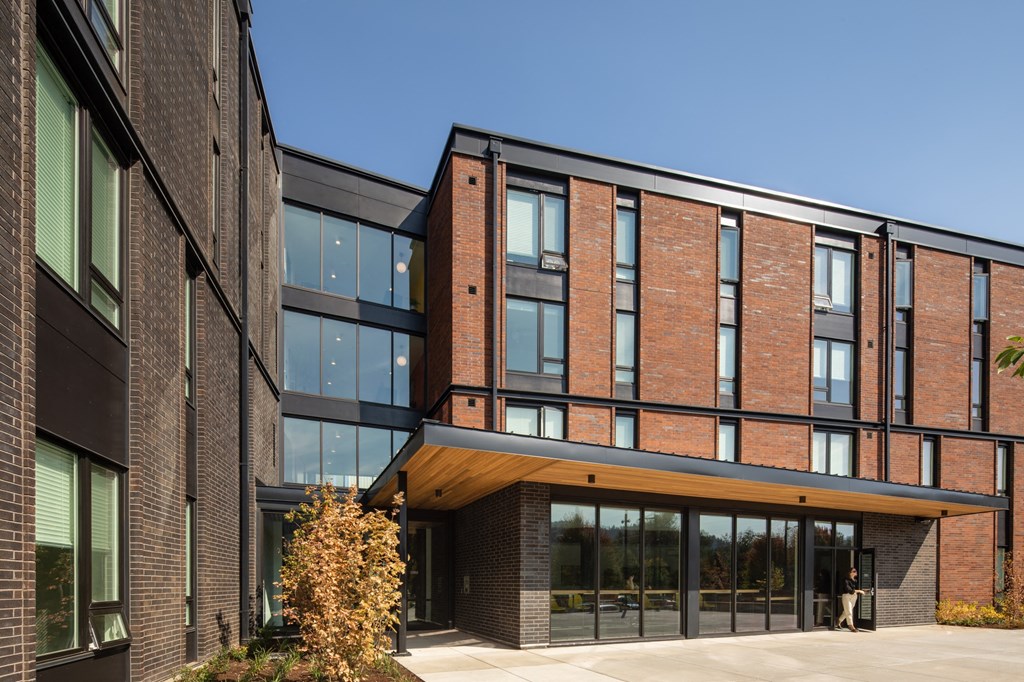 the front entrance of a brick building with large glass windows