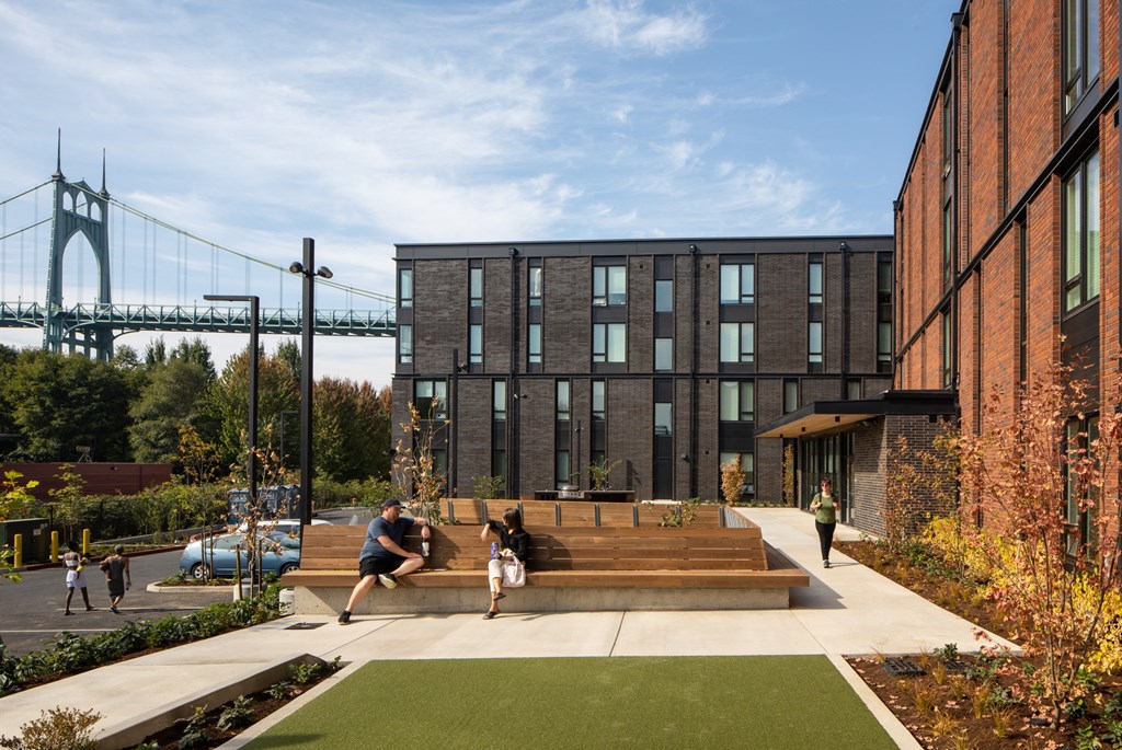 a park with a suspension bridge in the background
