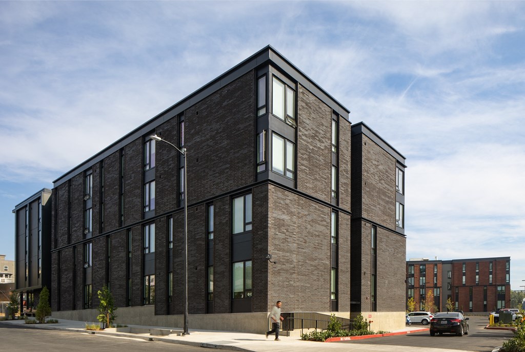 a large brick building with windows on the side of a street