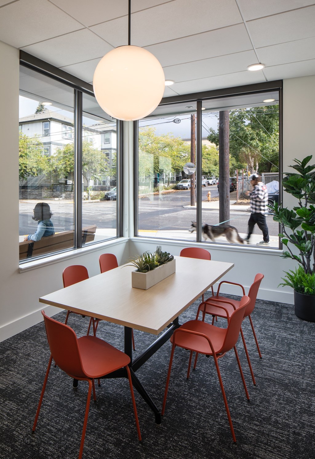 a meeting room with a table and chairs and a man walking down the street