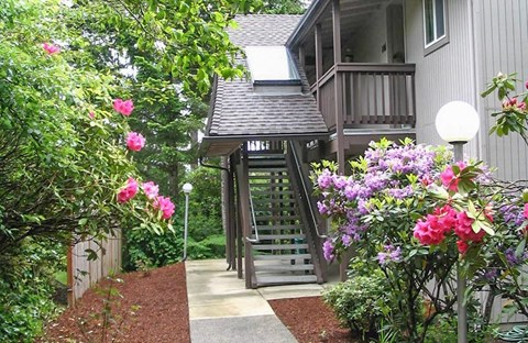 a house with a porch and a walkway with flowers