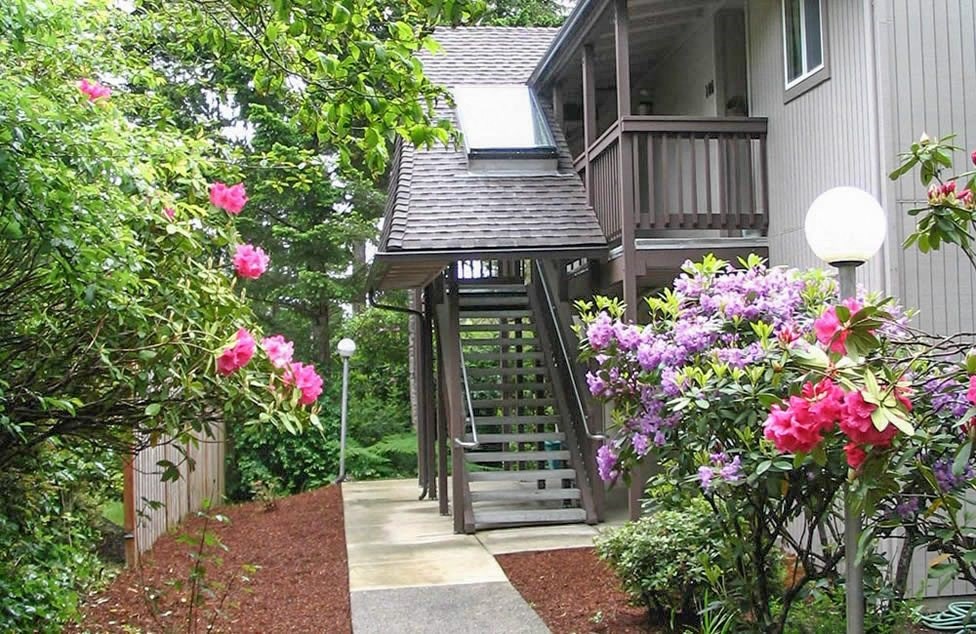 a house with a porch and a walkway with flowers