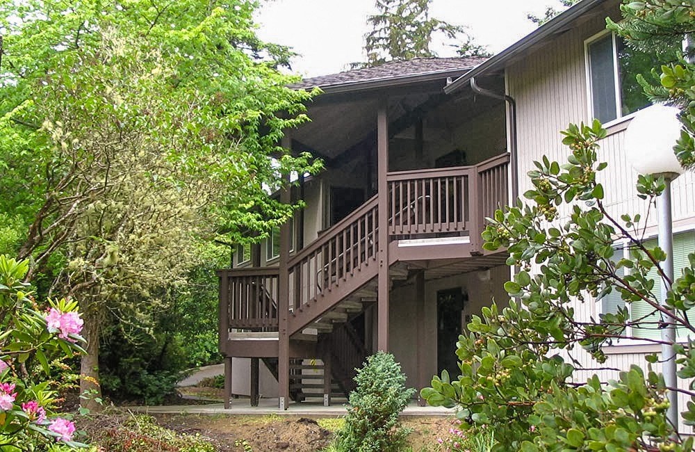 a house with a wooden deck on top of it