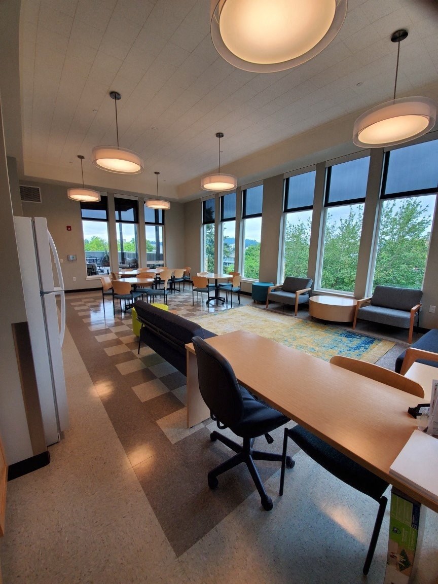 a large room with tables and chairs and windows