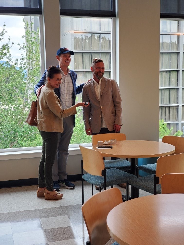 a group of people standing in a room with tables and chairs