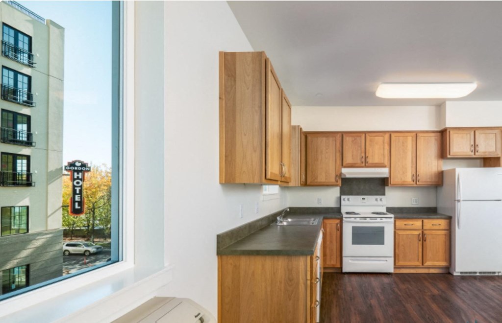 a kitchen with wooden cabinets and a large window