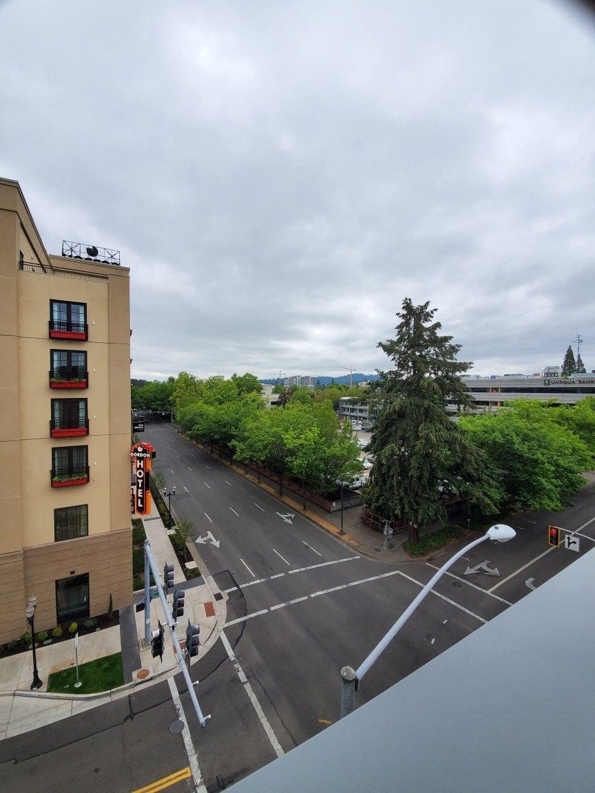 the view of an empty city street from a balcony