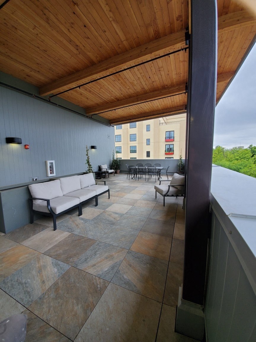a covered patio with couches and chairs and a table