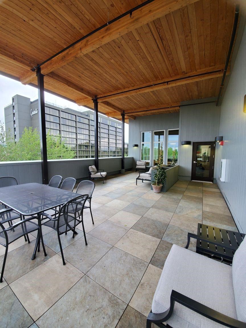 a patio with a table and chairs and a wooden ceiling