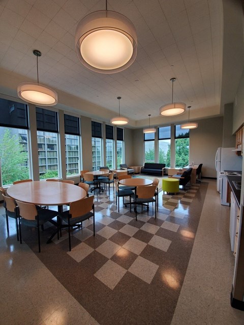 a dining room with tables and chairs in a building with large windows