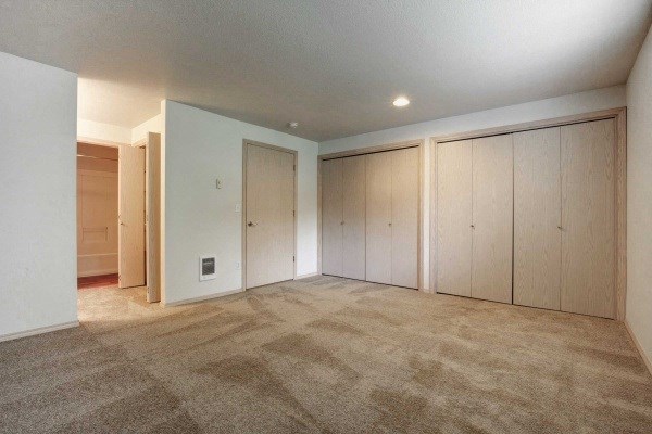 an empty living room with white cabinets and carpet