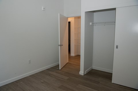 a bedroom with a closet and a door into a hallway