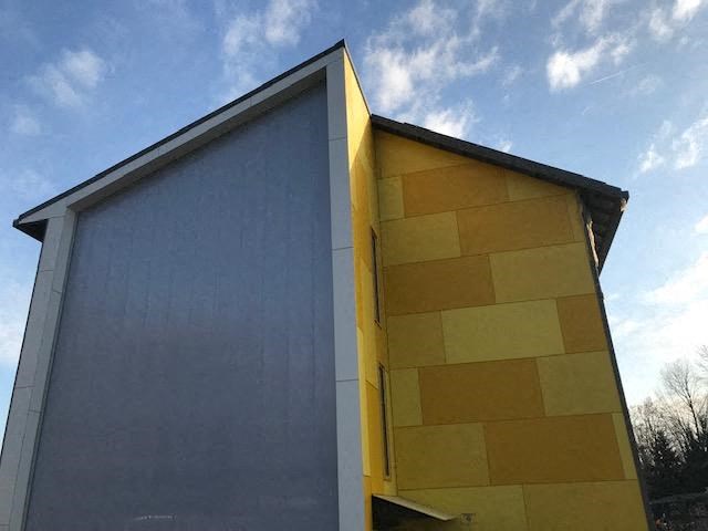 a yellow and blue building with a blue sky