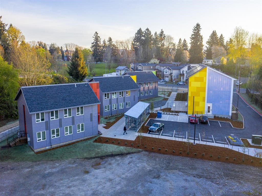 an aerial view of a group of houses and a large building