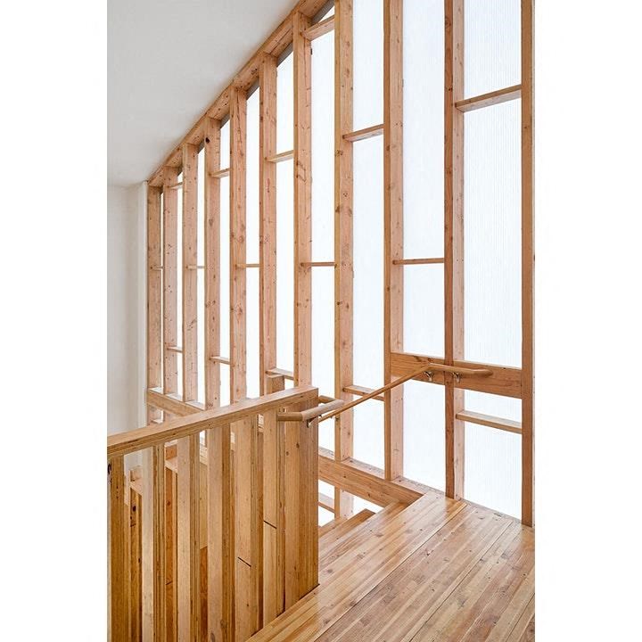a wooden staircase with a railing and a wall of windows