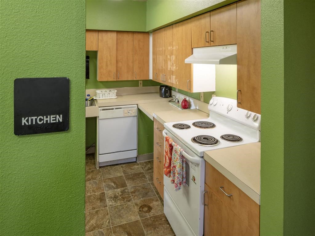 a kitchen with white appliances and green walls