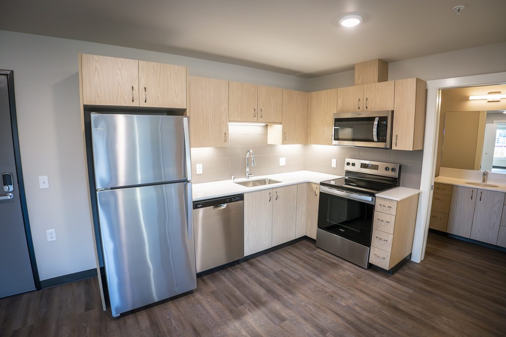A modern kitchen with stainless steel appliances and wooden cabinets.