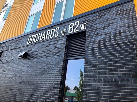 A building with a sign that says "Orchards of 82ND".