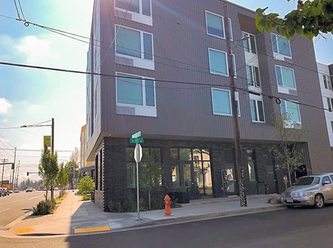 A modern building with a grey facade and a street in front.
