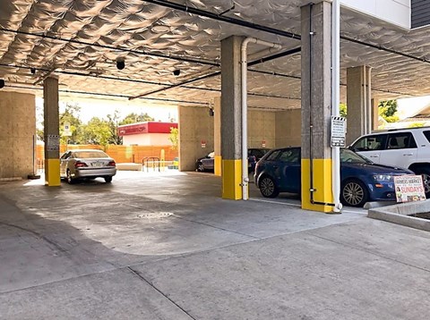 A parking garage with cars parked in yellow spaces.