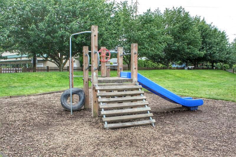 a playground with a blue slide and stairs