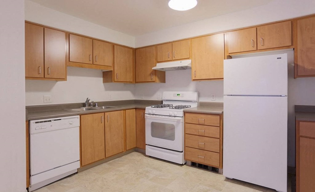 a kitchen with white appliances and wooden cabinets