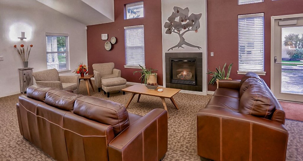 a living room with leather couches and a fireplace