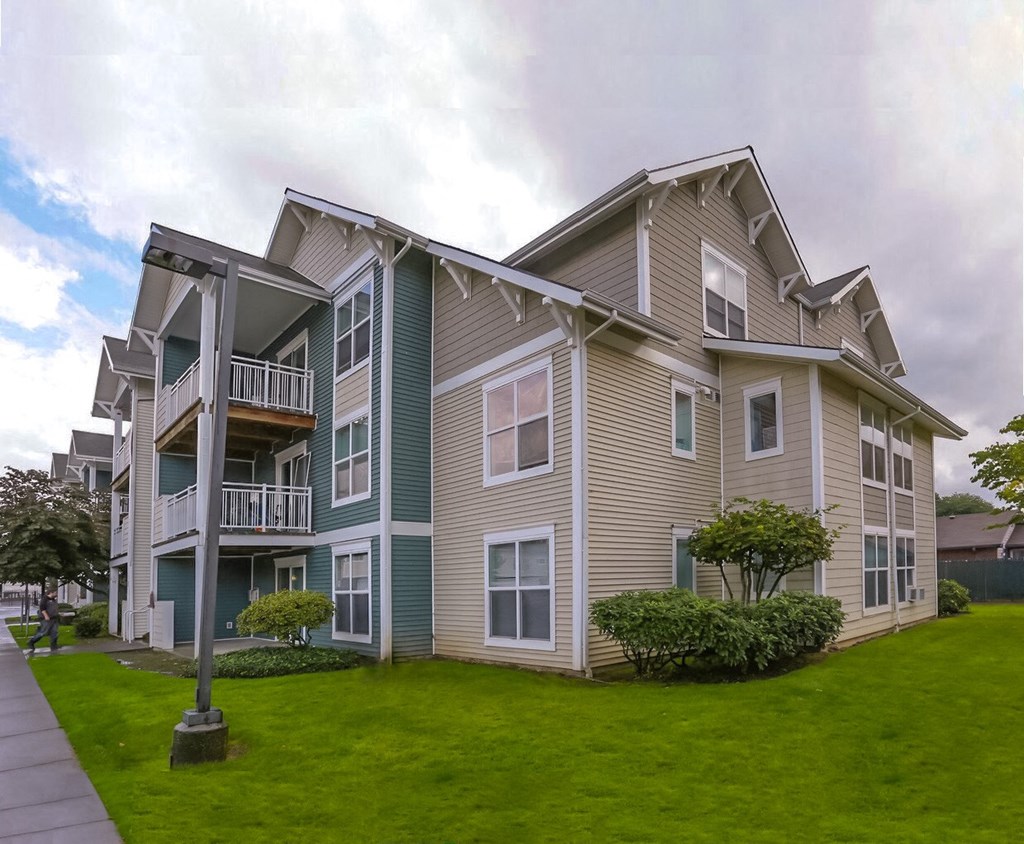 our apartments are located on the corner of a street with green grass